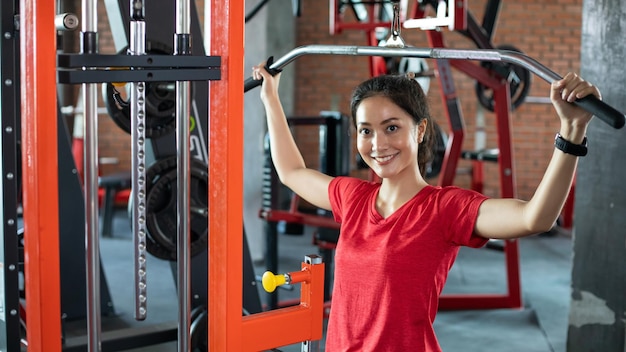 Bella donna in forma muscolare che esercita la costruzione di muscoli e donna fitness che fa esercizi in palestra Concetto di fitness di uno stile di vita sano