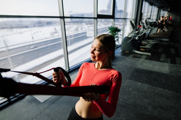 Bella donna in forma muscolare che si esercita, costruendo muscoli in palestra