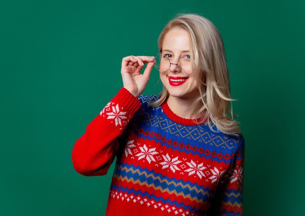 Bella donna in maglione e occhiali di Natale