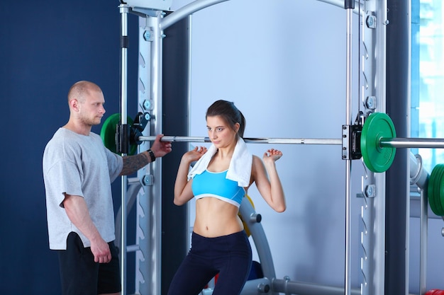 Bella donna in palestra che si esercita con il suo allenatore Bella donna Palestra