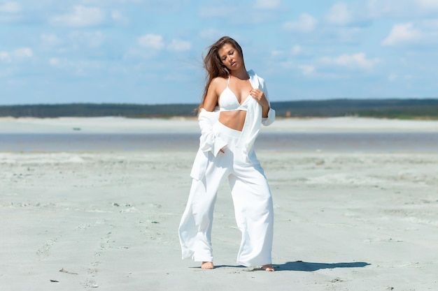 Bella donna in piedi sulla spiaggia