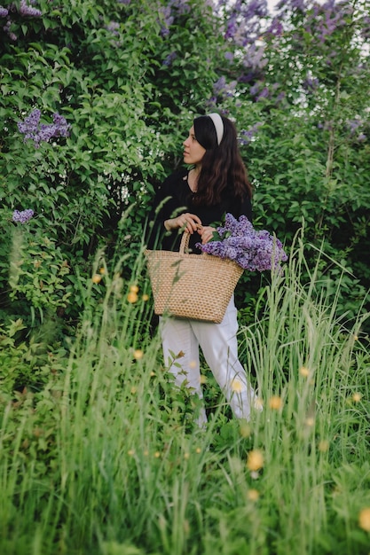 Bella donna in posa con fiori lilla l'estate sta arrivando