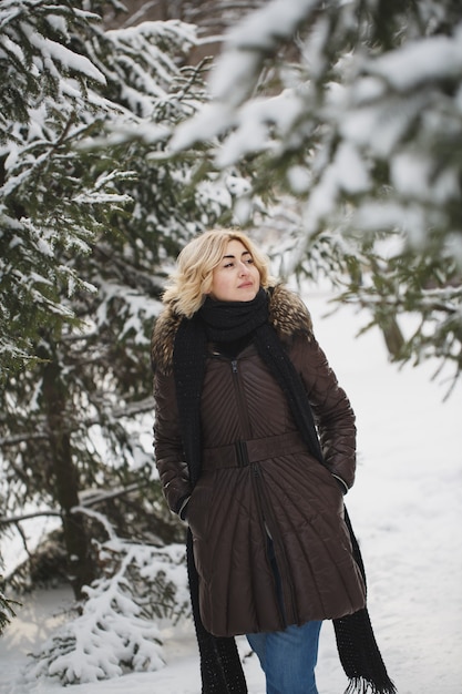 Bella donna in posa in una foresta invernale.