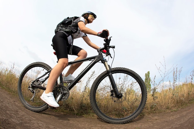 Bella donna in sella a una bicicletta in natura. Sport e ricreazione. Hobby e salute.