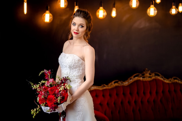 Bella donna in un abito da sposa con il bouquet da sposa