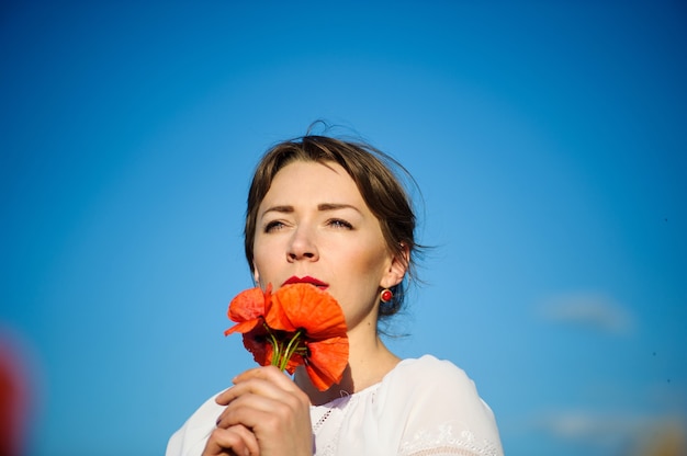 Bella donna in un campo di papaveri