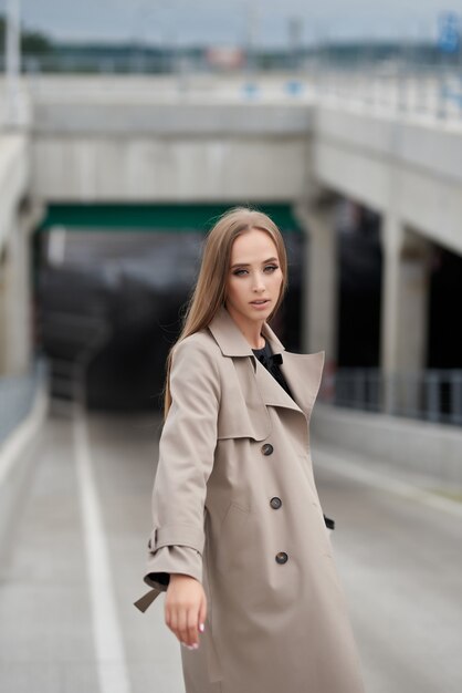 bella donna in un cappotto alla moda cammina per strada