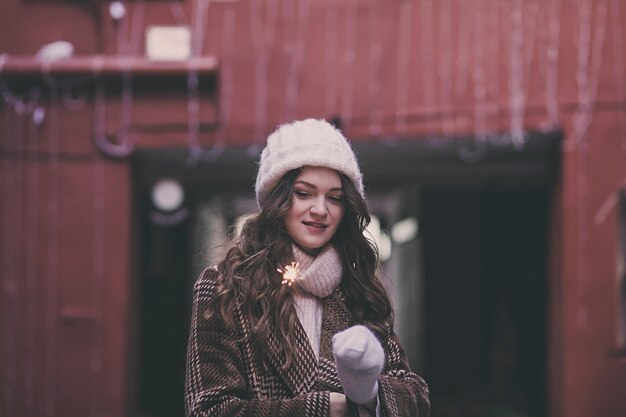 Bella donna in un cappotto invernale e un cappello con una stella filante