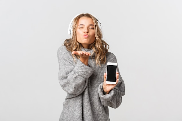 Bella donna in un maglione grigio in posa