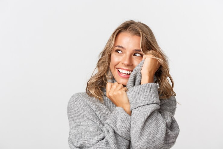 Bella donna in un maglione grigio in posa