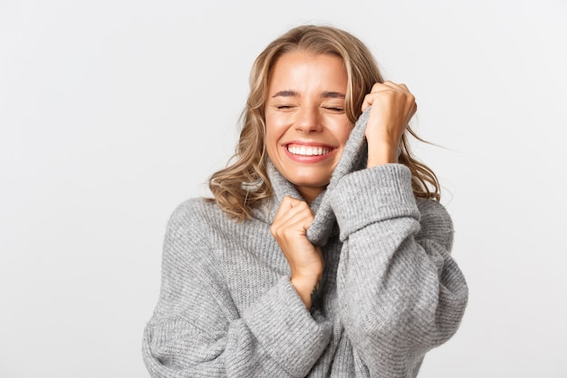 Bella donna in un maglione grigio in posa