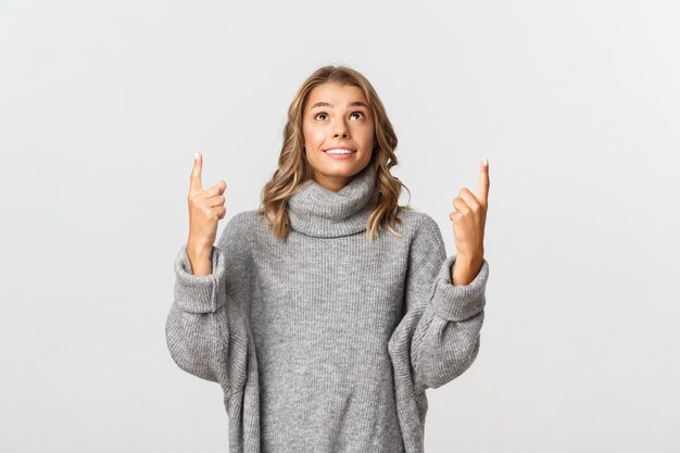 Bella donna in un maglione grigio in posa