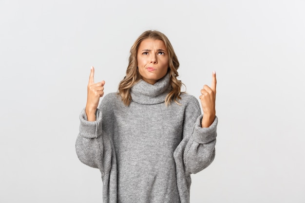 Bella donna in un maglione grigio in posa