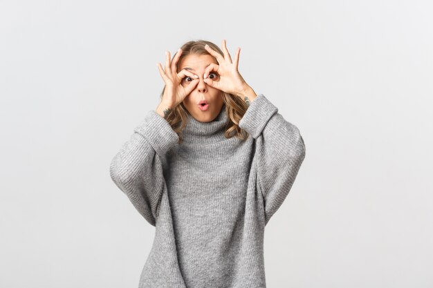 Bella donna in un maglione grigio in posa