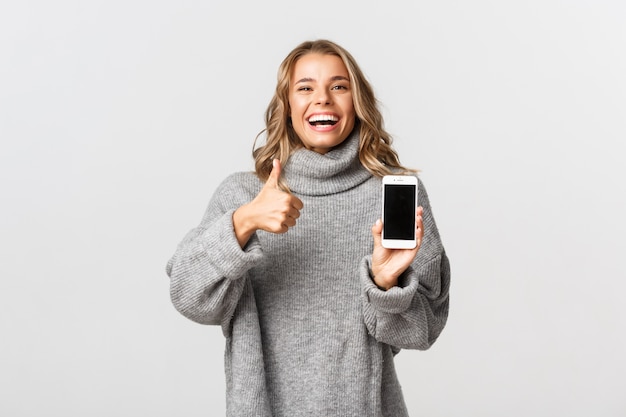 Bella donna in un maglione grigio in posa