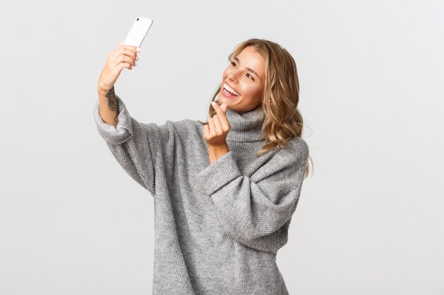 Bella donna in un maglione grigio in posa