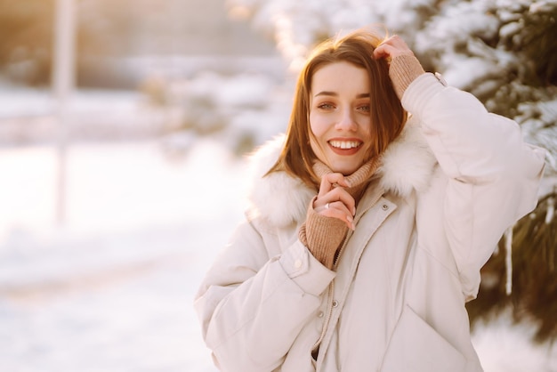 Bella donna in un parco innevato Giovane donna che cammina in una soleggiata giornata invernale