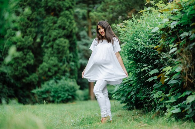 Bella donna incinta che si rilassa fuori nel parco