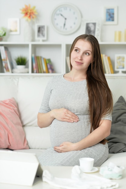 Bella donna incinta in posa sul divano