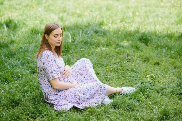 Bella donna incinta rilassante nel parco