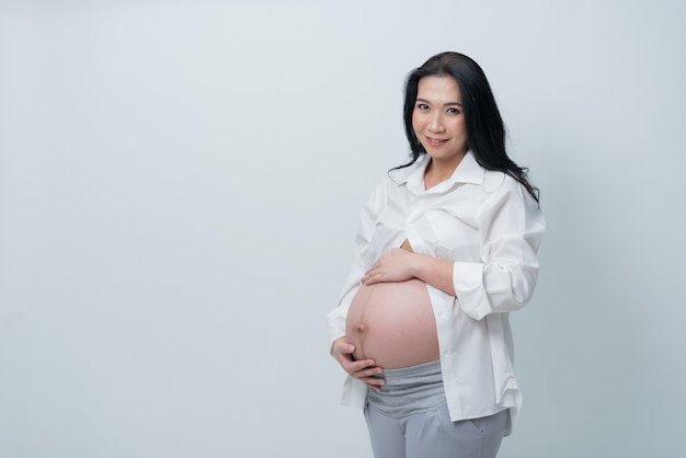 Bella donna incinta su sfondo bianco