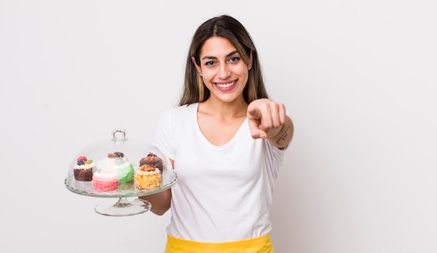 Bella donna ispanica che punta alla telecamera scegliendo il concetto di torte fatte in casa