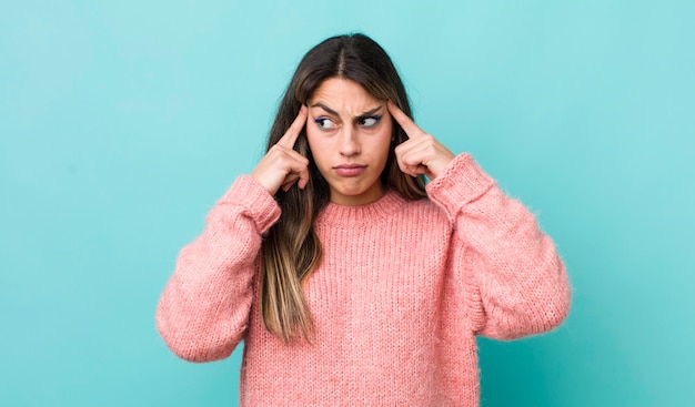 Bella donna ispanica che sembra concentrata e pensa intensamente a un'idea immaginando una soluzione a una sfida o a un problema