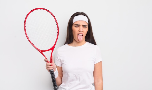 bella donna ispanica che si sente disgustata e irritata e con la lingua fuori. concetto di tennis