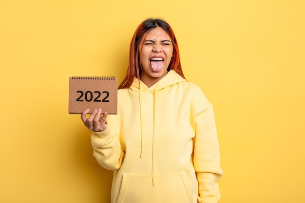 Bella donna ispanica che tiene un calendario o un'agenda 2022