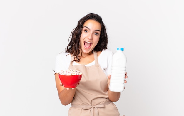 Bella donna ispanica chef che tiene in mano una ciotola per la colazione con latte