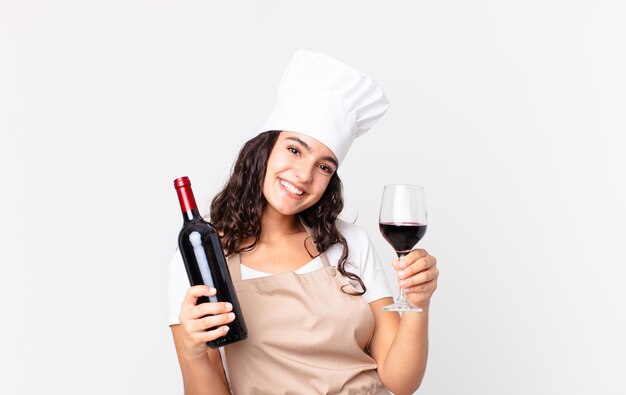 Bella donna ispanica chef con una bottiglia di vino