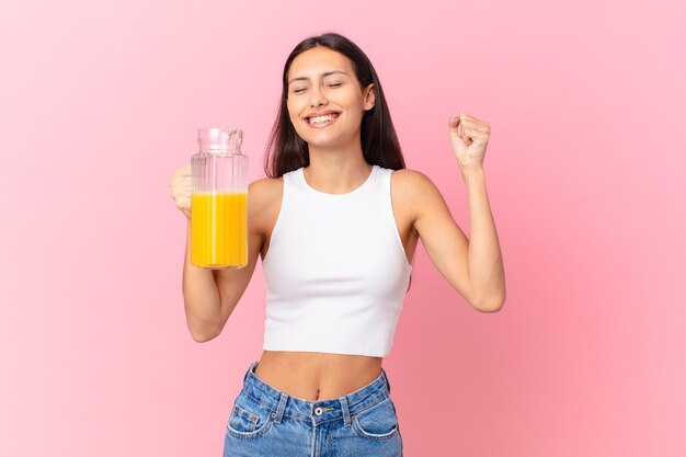 Bella donna ispanica con un succo d'arancia. concetto di colazione