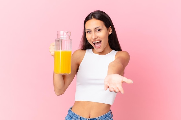 Bella donna ispanica con un succo d'arancia. concetto di colazione