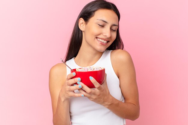 Bella donna ispanica con una ciotola per la colazione con fiocchi