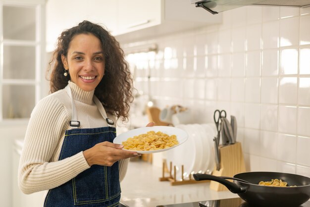 Bella donna latina che cucina in cucina