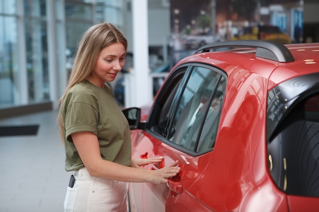 Bella donna matura che acquista un'auto nuova presso una concessionaria di auto