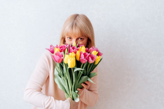 Bella donna matura che tiene i tulipani