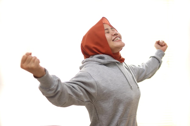 Bella donna musulmana asiatica che indossa l'hijab sente sollievo aria fresca vincente gesto espressioni felici