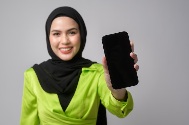 Bella donna musulmana con hijab utilizzando smartphone su sfondo bianco concetto tecnologico x9x9