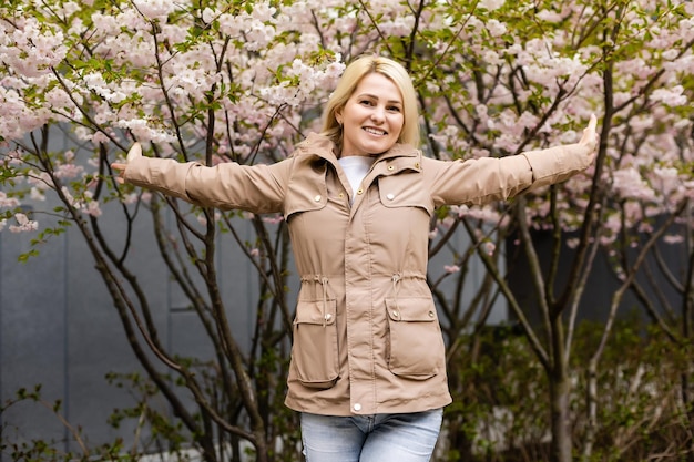 Bella donna nel giardino di fiori di ciliegio, primavera.