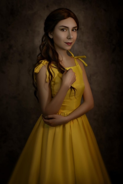 Bella donna nel primo piano del vestito giallo con una rosa rossa nelle sue maniBeauty and the beast cosplay