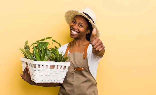 Bella donna nera che si sente orgogliosa di sorridere positivamente con i pollici in su