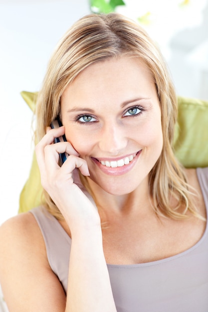 Bella donna parla al telefono sorridendo alla telecamera