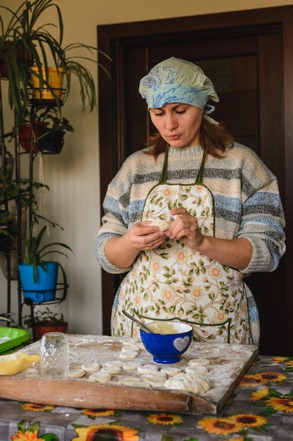 Bella donna prepara gnocchi nella sua cucina di casa gnocchi con patate