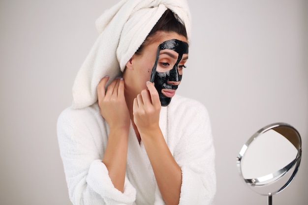 Bella donna rimuove una maschera detergente dal viso