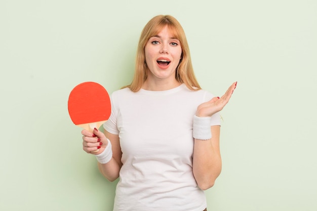 bella donna rossa che si sente felice e stupita da qualcosa di incredibile. concetto di ping pong