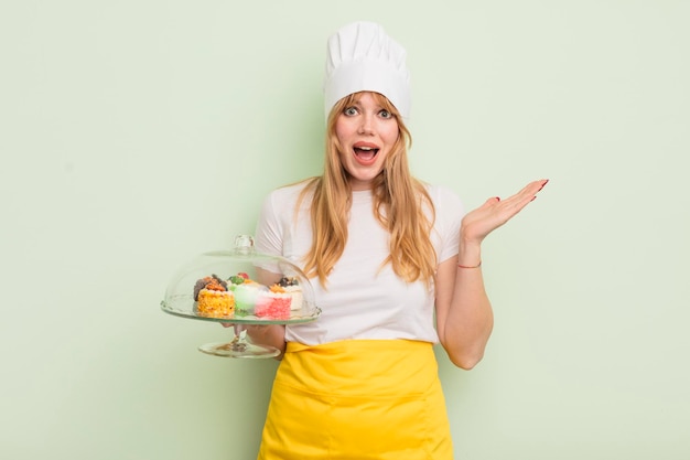 Bella donna rossa che si sente felice e stupita da qualcosa di incredibile concetto di torte fatte in casa