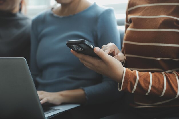 Bella donna seduta all'aperto e che utilizza al computer portatile Donna e amico che si divertono con le nuove tecnologie e lo shopping online in un luogo all'aperto