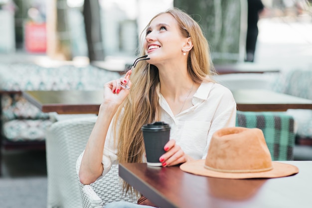 Bella donna seduta in un caffè di strada