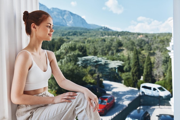 Bella donna seduta sul balcone vista città lifestyle